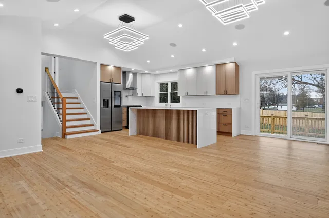 a view of kitchen with granite countertop cabinets and refrigerator