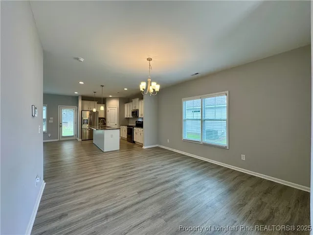a view of a living room a kitchen and a wooden floor