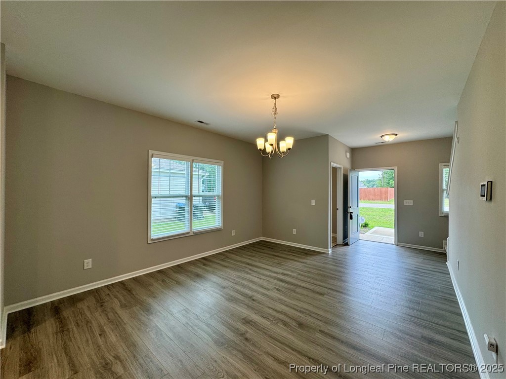 808 Jackson Street Raeford, NC 28376 - Photo 4 of 21 an empty room with wooden floor and windows