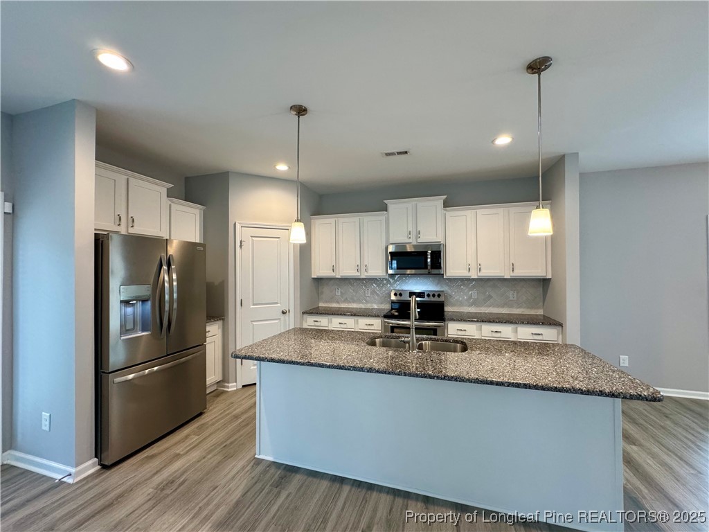 808 Jackson Street Raeford, NC 28376 - Photo 6 of 21 a kitchen with kitchen island a counter space a refrigerator and cabinets