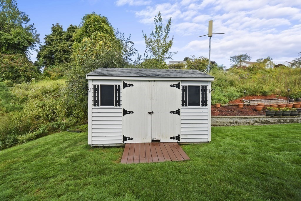 82 Buttermilk Road Leominster, MA 01453 - Photo 38 of 42 a view of a white house with a yard plants and large tree