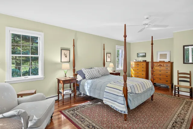 a bedroom with a bed chairs and a window