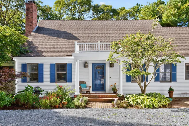 a kitchen with a refrigerator a sink dishwasher a dining table and chairs with wooden floor