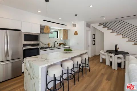 a kitchen with stainless steel appliances kitchen island a refrigerator and a stove