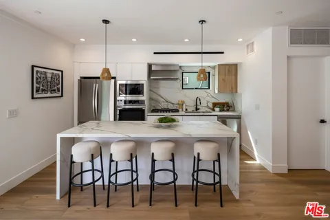 a kitchen with stainless steel appliances kitchen island a refrigerator and microwave