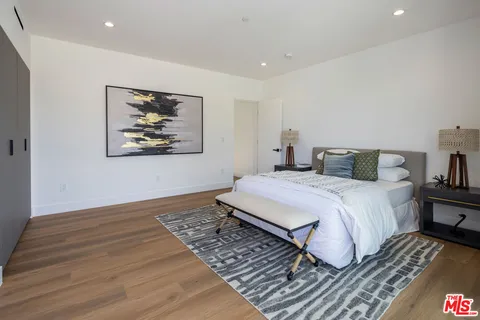 a bedroom with a bed and a painting on the wall