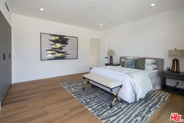 a bedroom with a bed and a painting on the wall