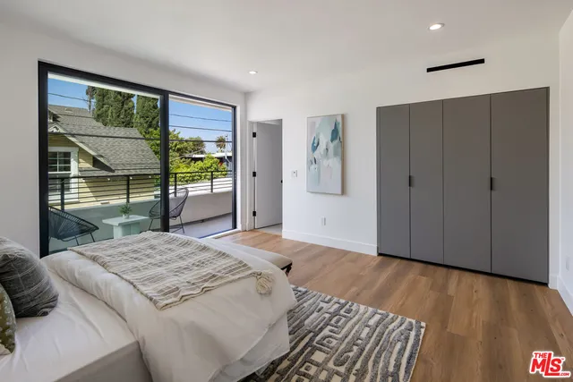a bedroom with a bed and a dresser next to a window
