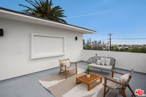 a roof deck with couch and potted plants