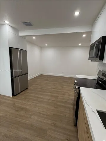 a view of storage and utility room with refrigerator