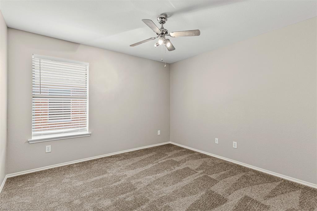 2821 Mockingbird Street Royse City, TX 75189 - Photo 15 of 21 an empty room with a chandelier fan and windows