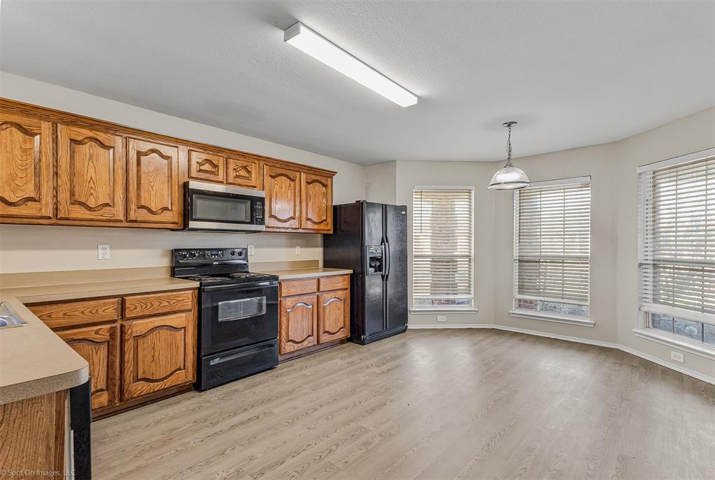 2821 Mockingbird Street Royse City, TX 75189 - Photo 6 of 21 a kitchen with stainless steel appliances granite countertop a refrigerator a stove top oven a sink dishwasher and white cabinets with wooden floor