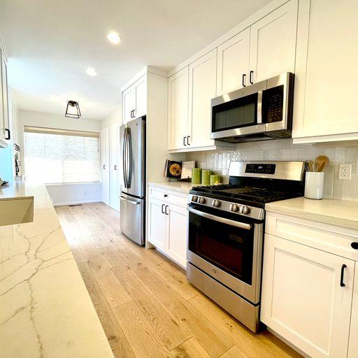 3850 Rio Road, Unit 91 Carmel, CA 93923 - Photo 11 of 31 a kitchen with stainless steel appliances granite countertop a stove a microwave and a refrigerator
