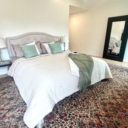 3850 Rio Road, Unit 91 Carmel, CA 93923 - Photo 17 of 31 a bedroom with a bed and painting on the wall