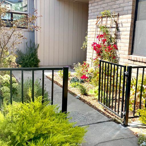 3850 Rio Road, Unit 91 Carmel, CA 93923 - Photo 2 of 31 a bunch of flowers in front of a wooden fence
