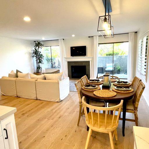 3850 Rio Road, Unit 91 Carmel, CA 93923 - Photo 8 of 31 a living room with furniture a fireplace and a chandelier