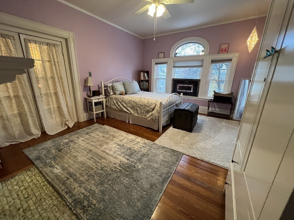 53 University Road, Unit 1 Brookline, MA 02445 - Photo 20 of 27 a bedroom with a bed window and a fireplace