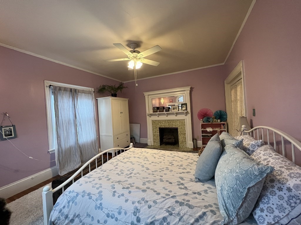 53 University Road, Unit 1 Brookline, MA 02445 - Photo 21 of 27 a spacious bedroom with a bed and a chandelier