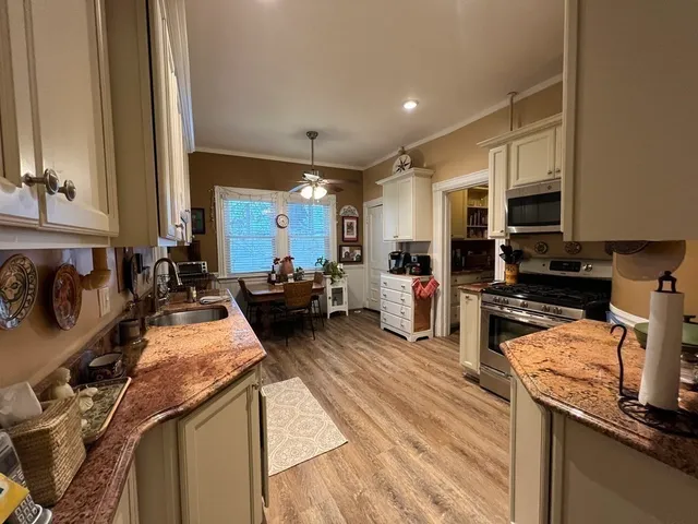 a kitchen with stainless steel appliances granite countertop a sink stove and refrigerator