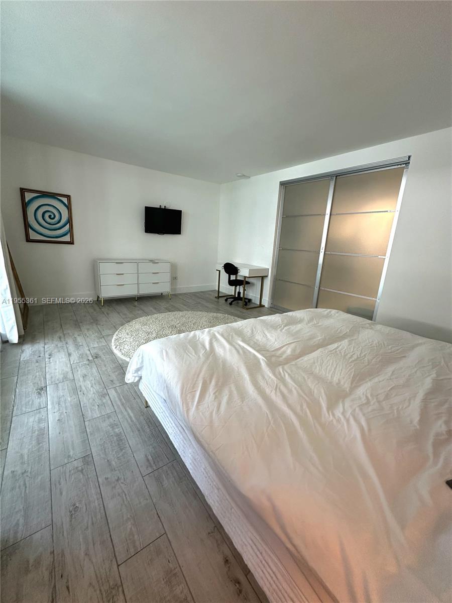 2301 Collins Avenue, Unit 321 Miami Beach, FL 33139 - Photo 12 of 16 a spacious bedroom with a bed and wooden floor