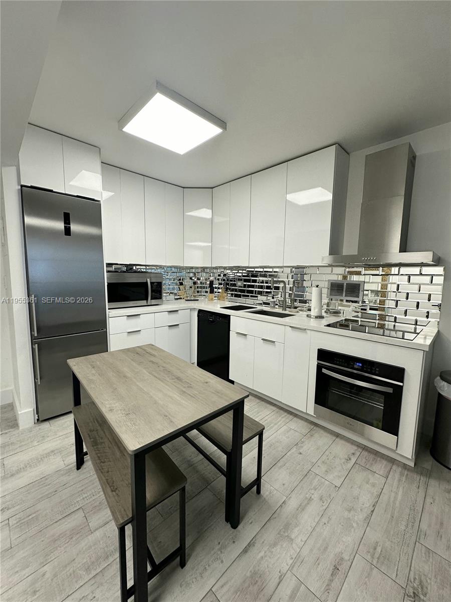 2301 Collins Avenue, Unit 321 Miami Beach, FL 33139 - Photo 8 of 16 a kitchen with kitchen island a stove a sink and a refrigerator