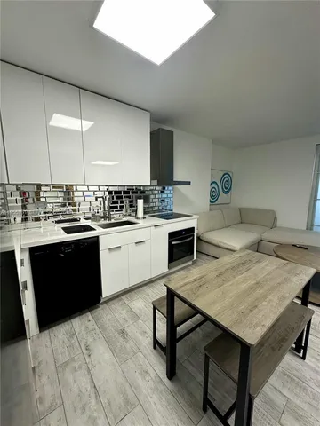 a kitchen with a sink cabinets and wooden floor