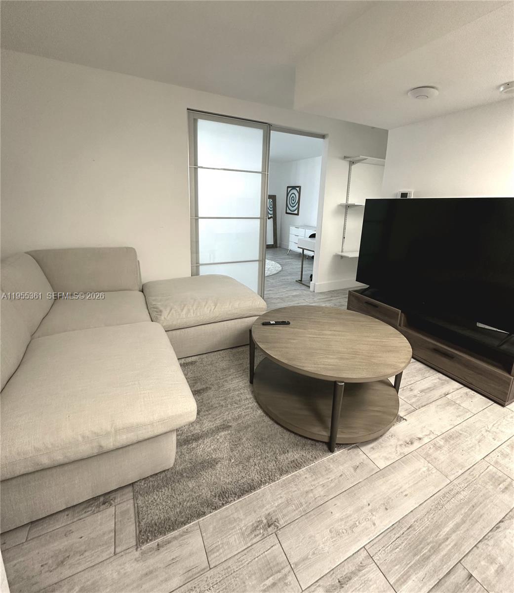 2301 Collins Avenue, Unit 321 Miami Beach, FL 33139 - Photo 10 of 16 a living room with furniture and a flat screen tv