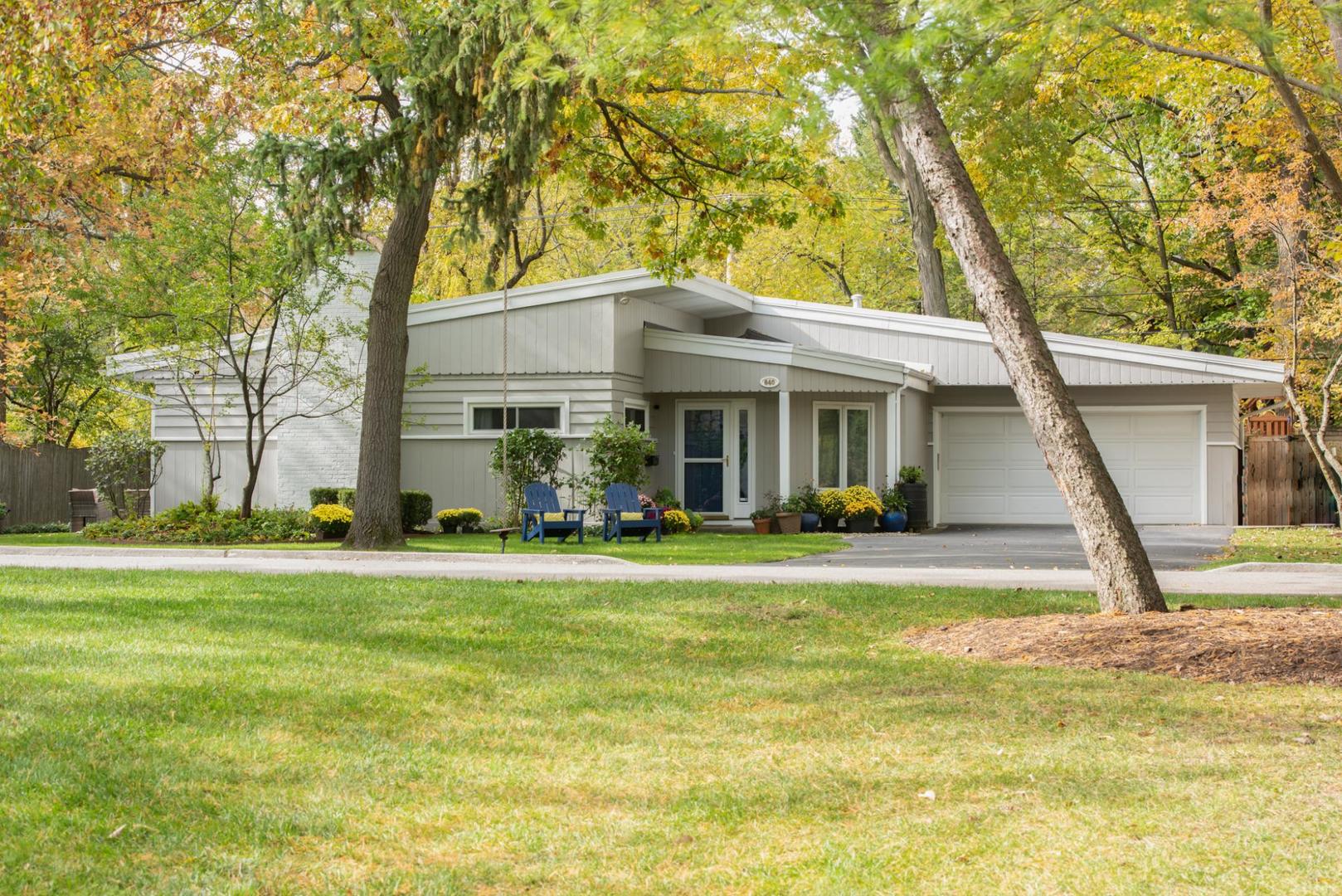 a view of a house with a big yard and large trees