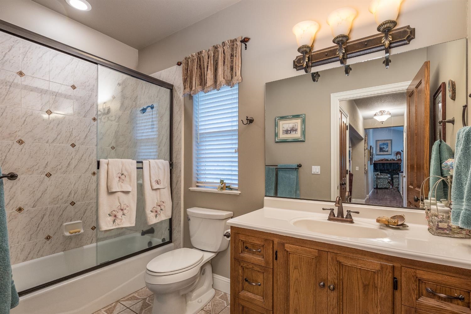 7703 Forest Drive Fish Camp, CA 93623 - Photo 19 of 48 a bathroom with a granite countertop toilet a sink and a large mirror