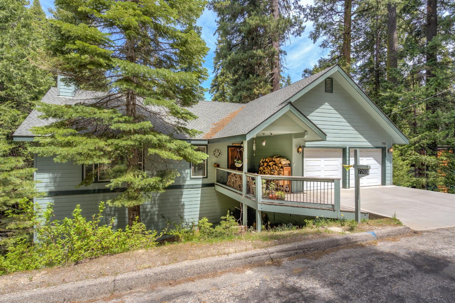7703 Forest Drive Fish Camp, CA 93623 - Photo 2 of 48 a front view of a house with a yard and potted plants