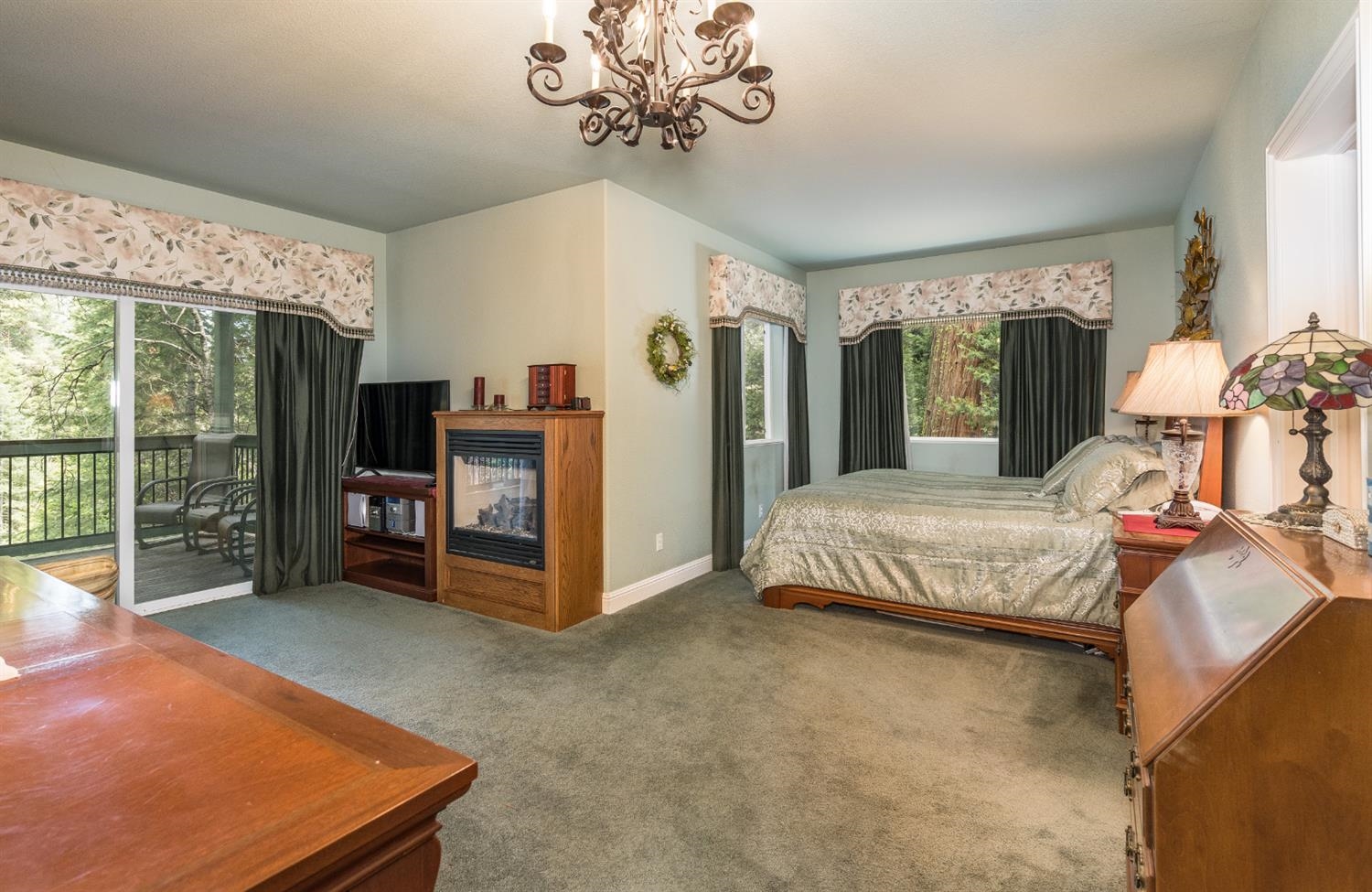 7703 Forest Drive Fish Camp, CA 93623 - Photo 32 of 48 a bedroom with a large bed and a chandelier