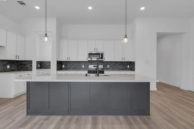 a kitchen with stainless steel appliances granite countertop a sink a stove and a refrigerator