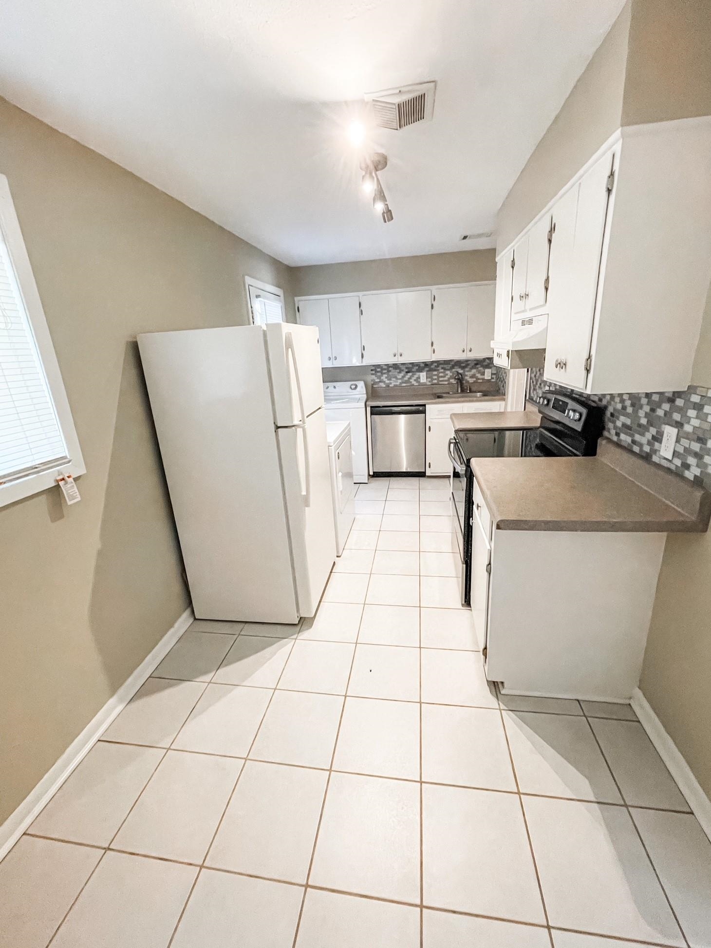 4773 Helene Road Memphis, TN 38117 - Photo 3 of 7 a kitchen with a sink a stove a refrigerator and cabinets