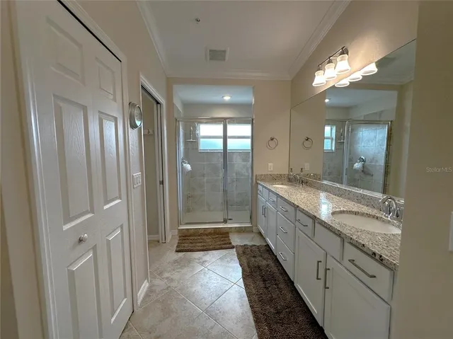 a bathroom with mirror double vanity and a shower