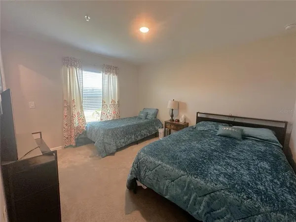 a bedroom with two beds and painting on the wall