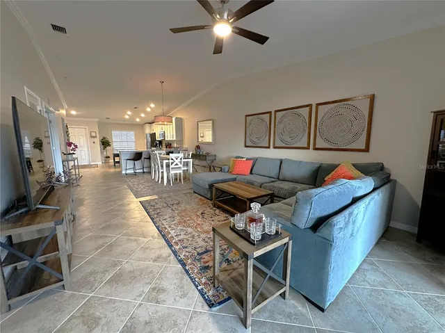 a living room with furniture a flat screen tv and a table