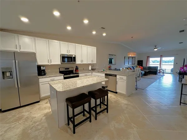 a kitchen with stainless steel appliances granite countertop a refrigerator sink and cabinets