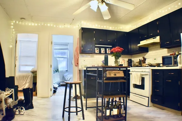 a kitchen with stainless steel appliances granite countertop a stove top oven a sink a dining table and chairs