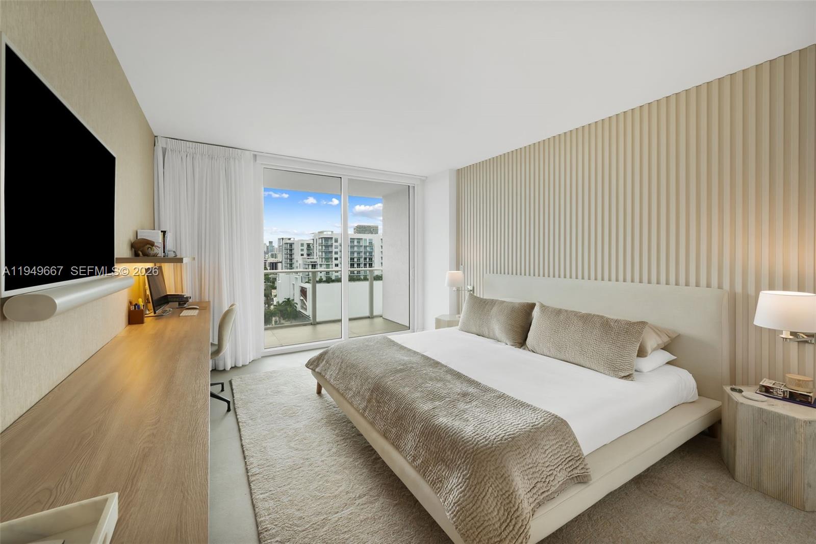 4250 Biscayne Boulevard, Unit 1201 Miami, FL 33137 - Photo 14 of 41 a spacious bedroom with a bed and a flat tv screen on the dresser