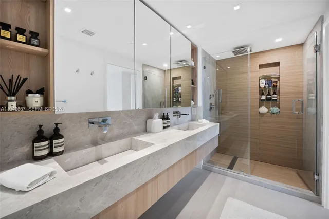 a bathroom with a double vanity sink mirror and shower