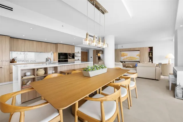 a view of a dining room with furniture a kitchen and chandelier
