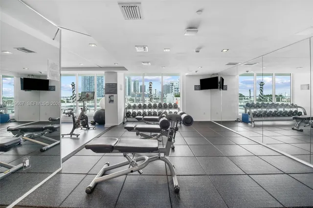 a room with gym equipment and a view of living room