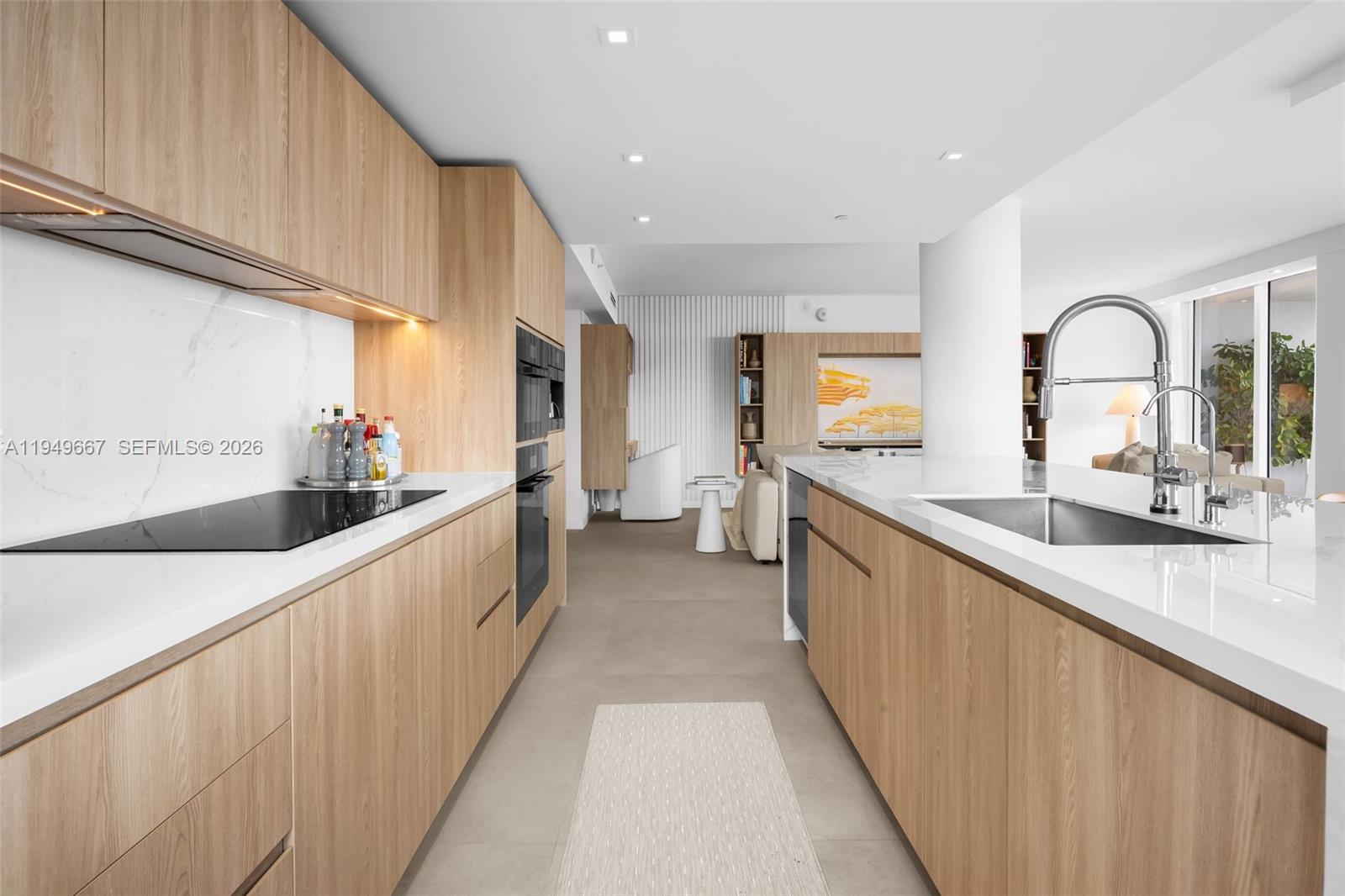 4250 Biscayne Boulevard, Unit 1201 Miami, FL 33137 - Photo 38 of 41 a large kitchen with stainless steel appliances a large counter top a stove top oven and cabinets