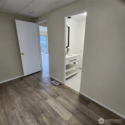 an empty room with wooden floor and closet