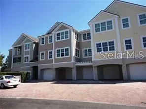 a front view of a building with a yard and parking space