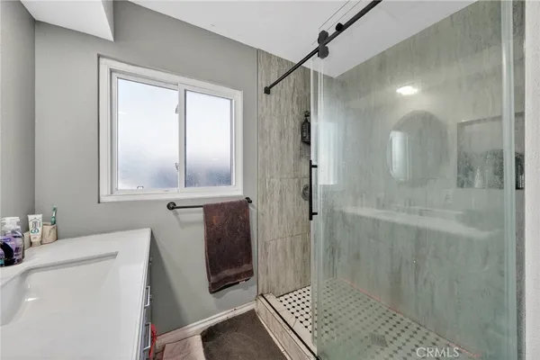 a bathroom with a shower sink and mirror