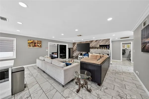 a kitchen with stainless steel appliances a dining table chairs and refrigerator