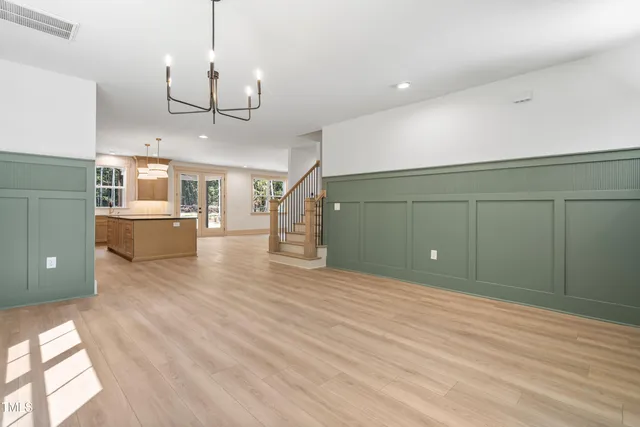 a view of a big room with wooden floor and windows
