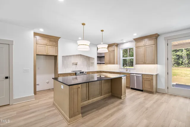 a kitchen with a stove a sink a refrigerator and window