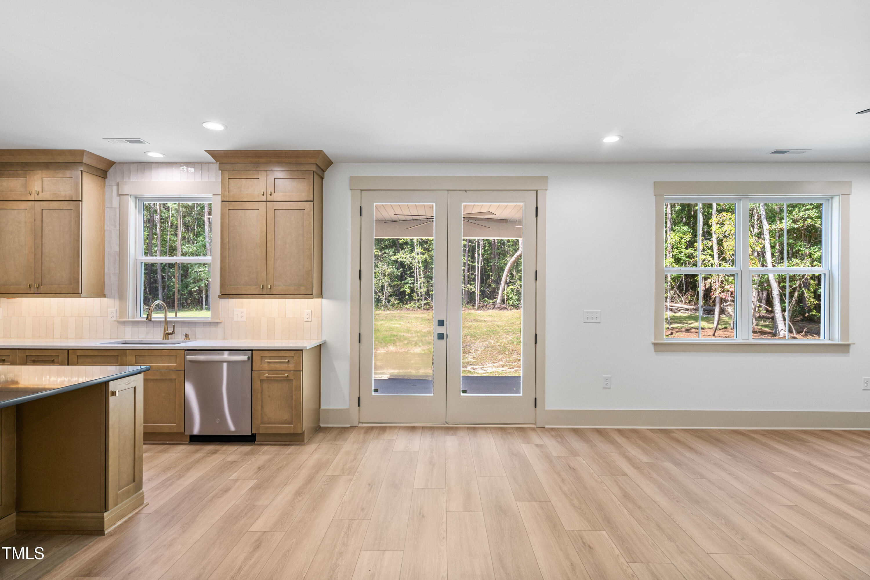 312 Russ Road Smithfield, NC 27577 - Photo 22 of 60 a view of a kitchen with kitchen island a sink wooden floor and a large window